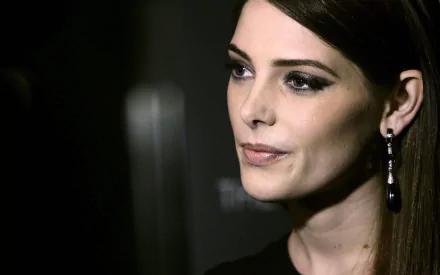 Close-up face portrait of a woman with dark hair, smoky eye makeup and dangling earring, subtle smile — 2K Quad HD PC desktop wallpaper background.