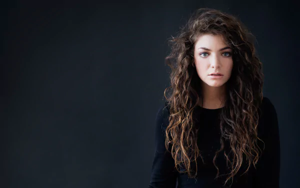 HD PC desktop wallpaper featuring a portrait of musician Lorde with long curly hair against a dark background.
