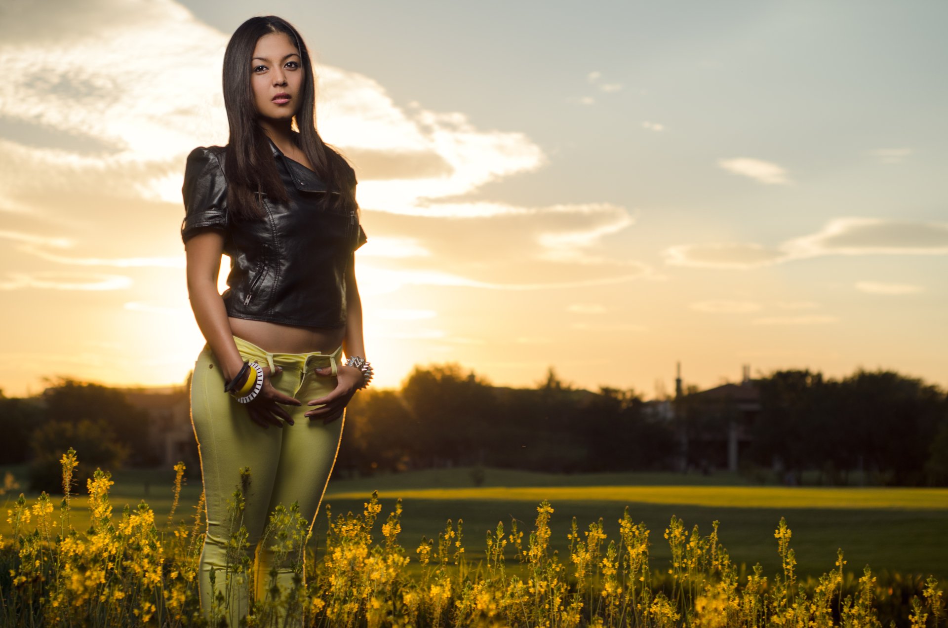 HD desktop wallpaper featuring a woman standing in a field of yellow flowers at sunset, conveying a serene mood.