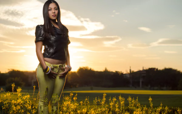 HD desktop wallpaper featuring a woman standing in a field of yellow flowers at sunset, conveying a serene mood.