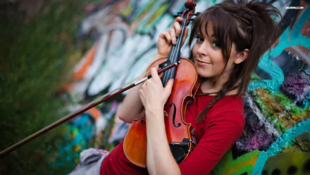 HD desktop wallpaper featuring musician Lindsey Stirling playing the violin against a colorful graffiti background.