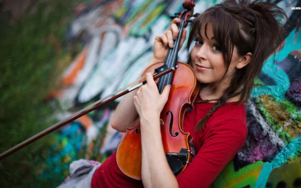 HD desktop wallpaper featuring musician Lindsey Stirling playing the violin against a colorful graffiti background.
