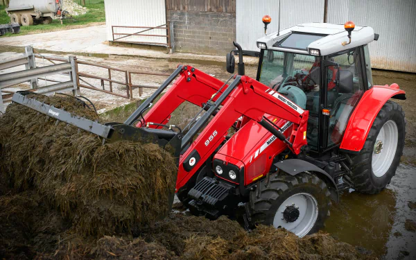 A vibrant HD desktop wallpaper featuring a Massey Ferguson tractor working in a farmyard, lifting and moving hay with its front loader in a rural setting.