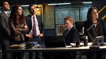 HD desktop wallpaper from The Blacklist featuring the main characters in a strategic meeting within their task force headquarters.