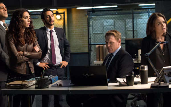 HD desktop wallpaper from The Blacklist featuring the main characters in a strategic meeting within their task force headquarters.