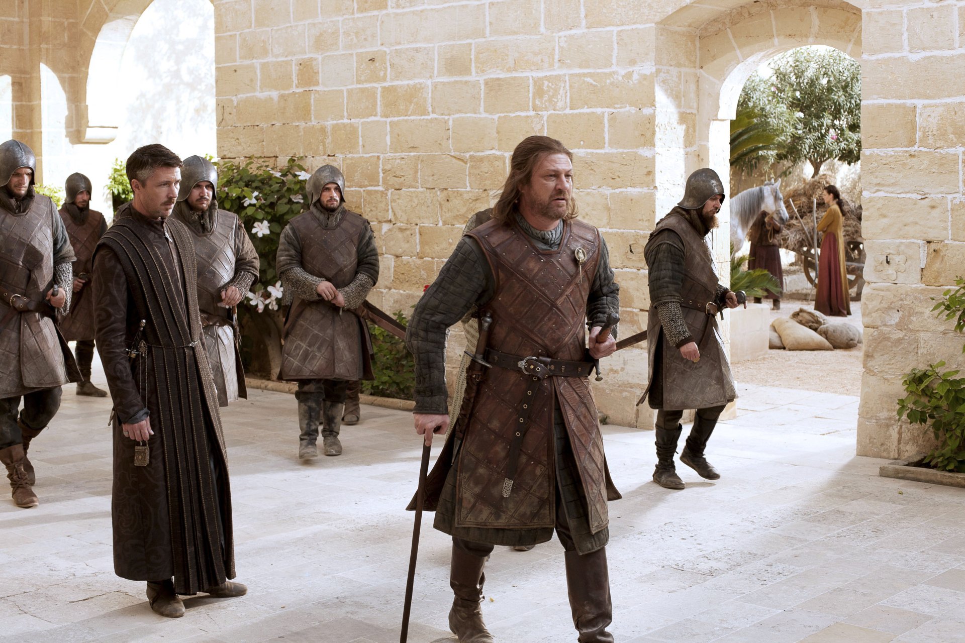 HD PC desktop wallpaper from Game of Thrones featuring Sean Bean as Eddard Stark and Aidan Gillen as Petyr Baelish in a castle courtyard scene.