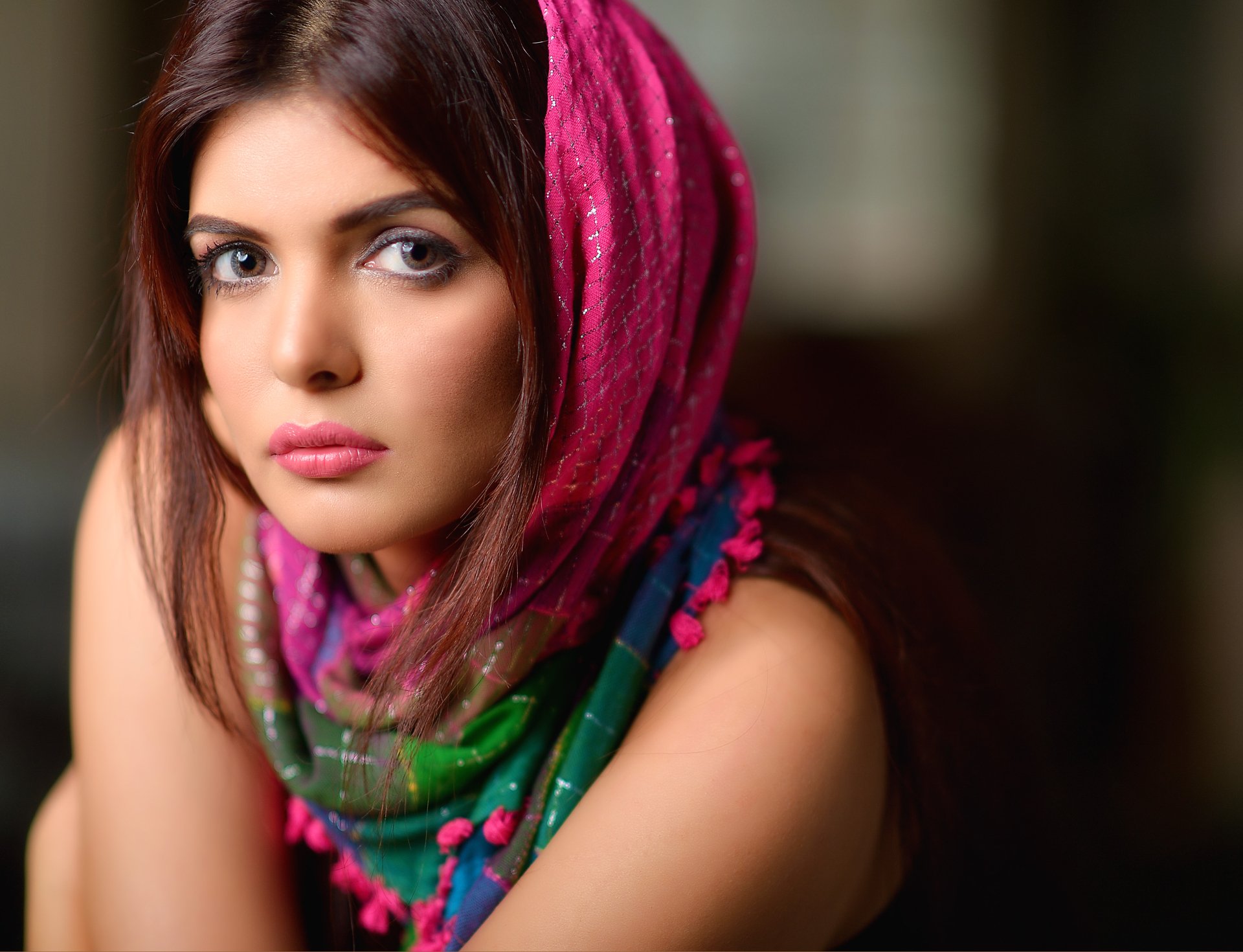 A striking HD desktop wallpaper of Indian model Ihana Dhillon, showcasing her expressive gaze and vibrant scarf, which adds color and depth to the image.