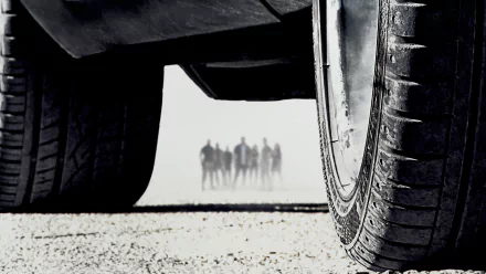 HD desktop wallpaper of Furious 7 from the Fast & Furious movie series, featuring a close-up of a car tire with a group of people standing in the background.
