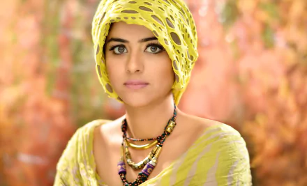 A stunning HD wallpaper featuring Prachi Tehlan, an Indian model, showcasing her beauty with expressive eyes and adorned in a vibrant yellow outfit and accessories.