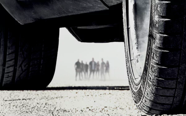 HD desktop wallpaper of Furious 7 from the Fast & Furious movie series, featuring a close-up of a car tire with a group of people standing in the background.