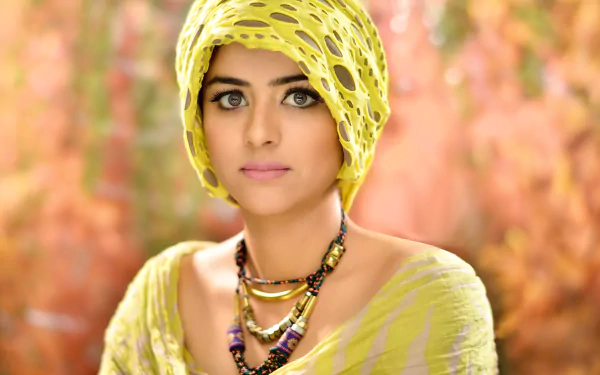 A stunning HD wallpaper featuring Prachi Tehlan, an Indian model, showcasing her beauty with expressive eyes and adorned in a vibrant yellow outfit and accessories.