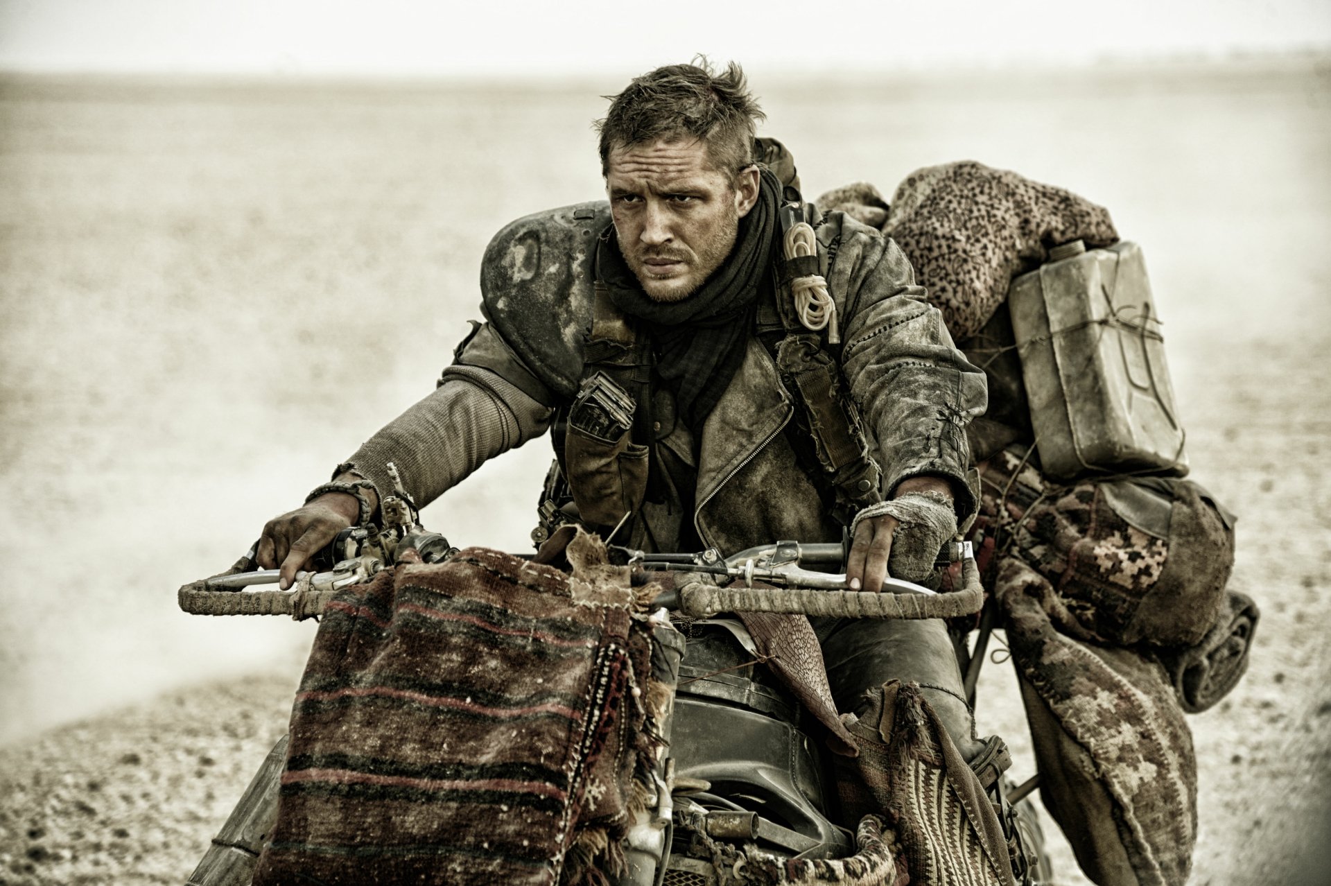 Max Rockatansky, played by Tom Hardy, rides a rugged motorcycle in a desert scene from the movie Mad Max: Fury Road, captured in 4K Ultra HD.