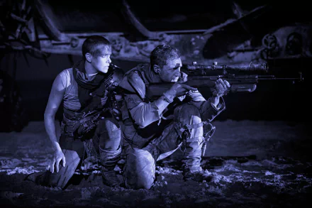 A dramatic black and white scene from Mad Max: Fury Road featuring Imperator Furiosa (Charlize Theron) and Max Rockatansky (Tom Hardy) in a tense moment.