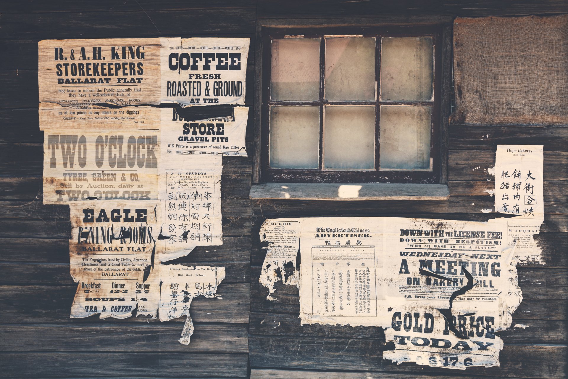 4K Ultra HD wallpaper featuring a rustic man-made wall covered with vintage, weathered posters and notices next to an old wooden window.