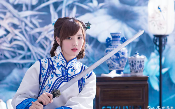 A Taiwanese woman named Yu Chen Zheng in traditional costume holds a sword amid blue-and-white vases and a lantern, captured in a 4K Ultra HD desktop wallpaper.