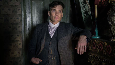 Cillian Murphy as Thomas Shelby in a striking scene from Peaky Blinders, showcasing his intense expression and stylish period attire, capturing the show's atmospheric essence.