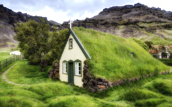HD wallpaper of a quaint church with a grass roof in the picturesque countryside of Iceland, set against mountainous terrain, captured in vibrant HDR.