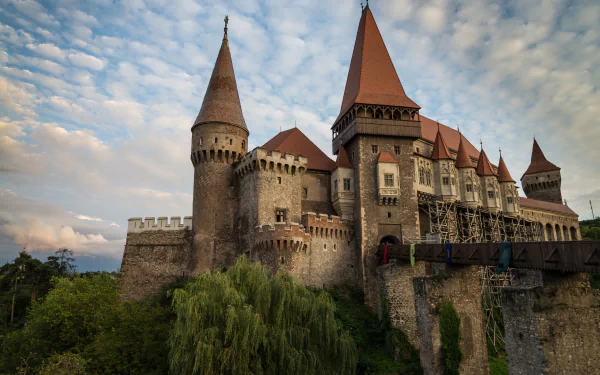 Corvin Castle, a grand man-made fortress in Romania, captured in stunning 4K Ultra HD, showcasing its medieval towers under a dramatic sky.