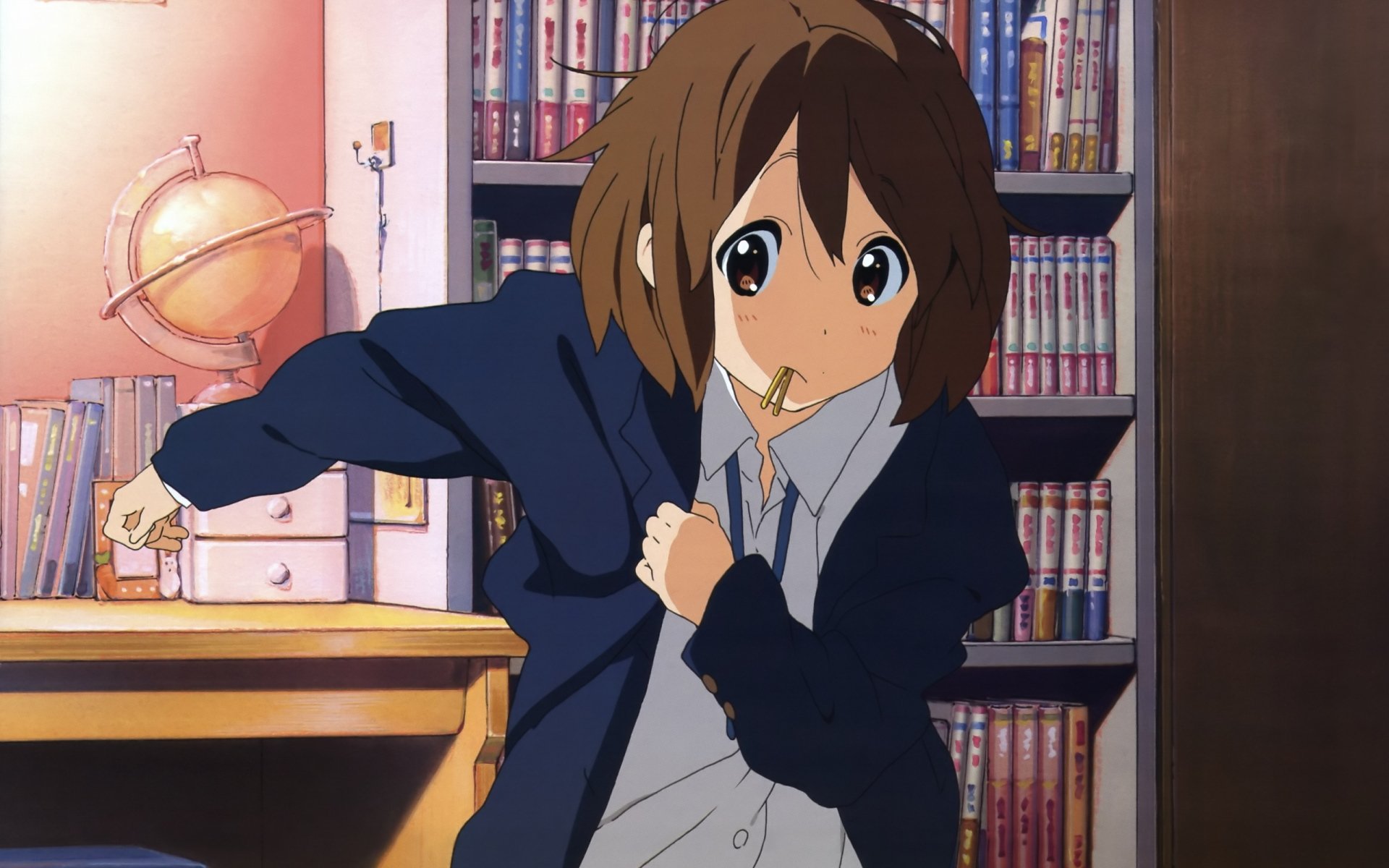 2K Quad HD anime desktop wallpaper of Yui Hirasawa (K-ON!) with short brown hair and brown eyes, tugging her jacket in a cozy room lined with bookshelves and a desk.