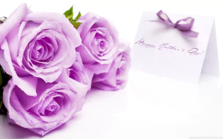 A serene desktop wallpaper featuring soft lavender roses alongside a greeting card, celebrating Mother's Day with elegance and warmth.