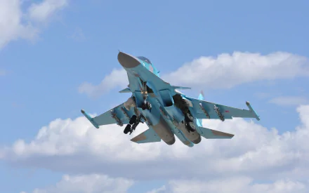 Sukhoi Su-34 military jet fighter in turquoise camo ascending against a blue sky — 2K Quad HD PC desktop wallpaper background.