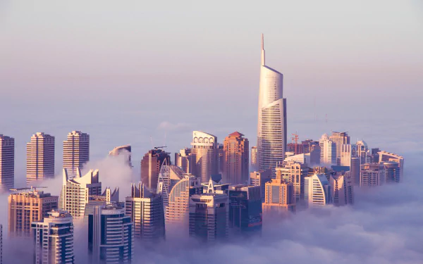 A 4K Ultra HD view of Dubai's Jumeirah Lake Tower and Sheikh Zayed Avenue skyscrapers emerging through clouds and fog in a striking man-made cityscape.