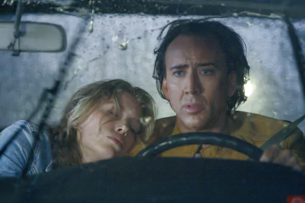 Nicolas Cage and Jessica Biel share a tense moment in a car during a rainstorm, as seen in the movie Next. This HD wallpaper captures the film's dramatic atmosphere.