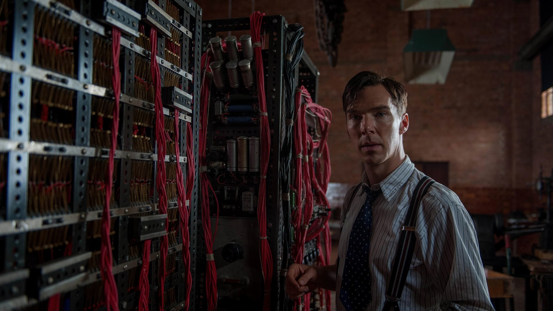 Benedict Cumberbatch in a scene from The Imitation Game, standing near a complex array of wires and machinery, capturing a pivotal moment in the film. HD desktop wallpaper.