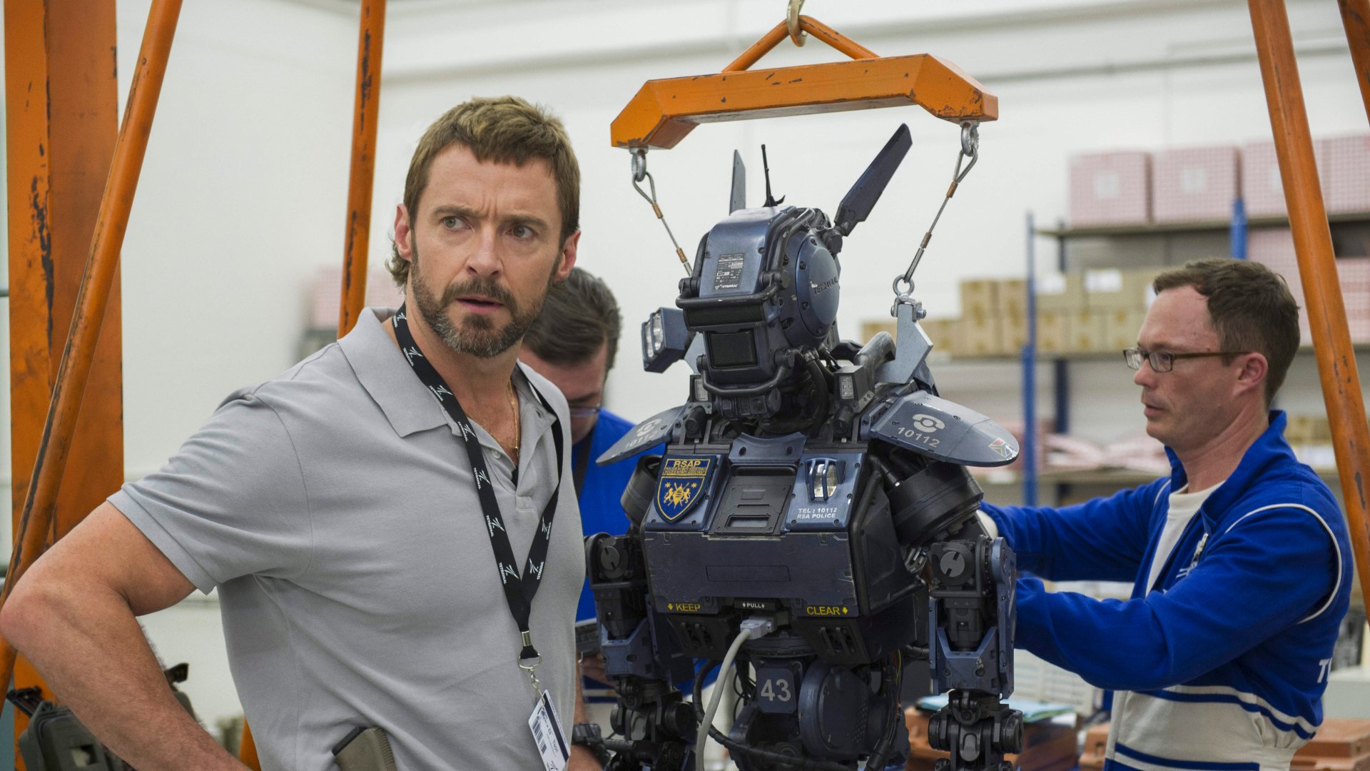 Hugh Jackman and Vincent Moore with the robot from the movie Chappie, featured in a 4K Ultra HD PC desktop wallpaper and background.