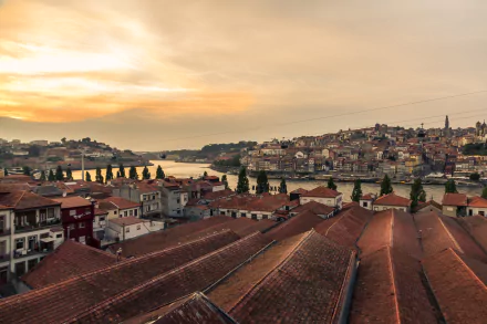5K Ultra HD desktop wallpaper: Porto at sunset over the Douro River, evening man-made cityscape of terracotta rooftops and riverside houses in Portugal.