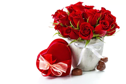A vibrant arrangement of red roses in a vase beside a heart-shaped box of chocolates, symbolizing love and romance. This HD image serves as an elegant desktop wallpaper.
