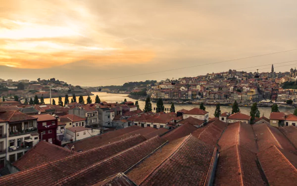 5K Ultra HD desktop wallpaper: Porto at sunset over the Douro River, evening man-made cityscape of terracotta rooftops and riverside houses in Portugal.