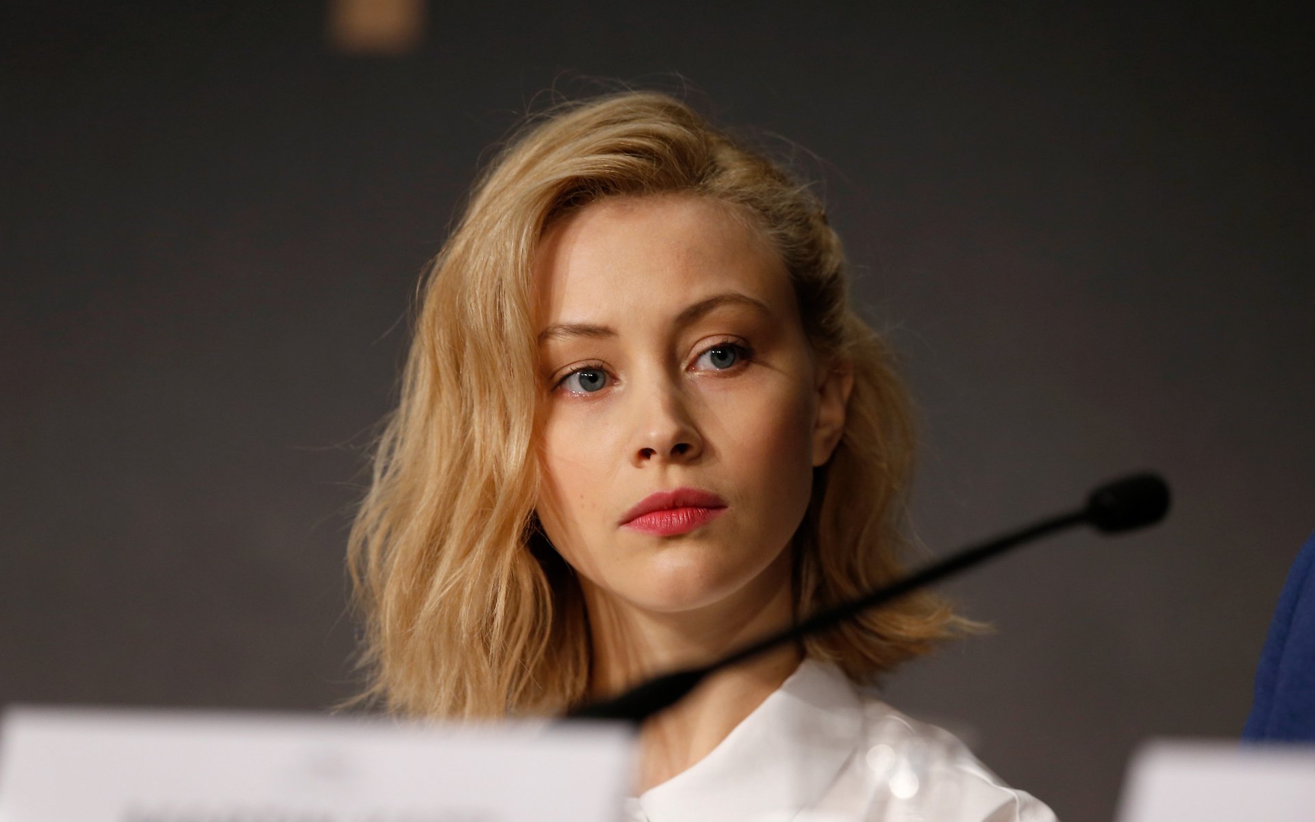Close-up portrait of Canadian actress Sarah Gadon with blonde hair and blue eyes, featured in a high-definition PC desktop wallpaper background.