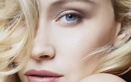 Close-up HD portrait of Canadian actress Sarah Gadon with blonde hair and striking blue eyes, designed as a desktop wallpaper background.