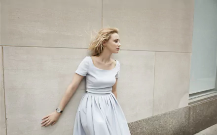 HD PC desktop background: blonde woman with blue eyes in a pale dress leaning against a beige wall.