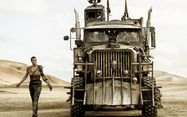 Imperator Furiosa, portrayed by Charlize Theron, strides toward a rugged vehicle in a desolate landscape from Mad Max: Fury Road, showcasing a powerful cinematic moment.