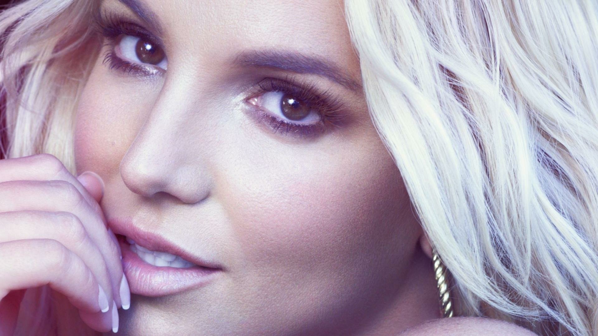 Close-up of Britney Spears, capturing her expressive eyes and soft features, set against a vibrant, colorful background, making a striking HD PC desktop wallpaper.
