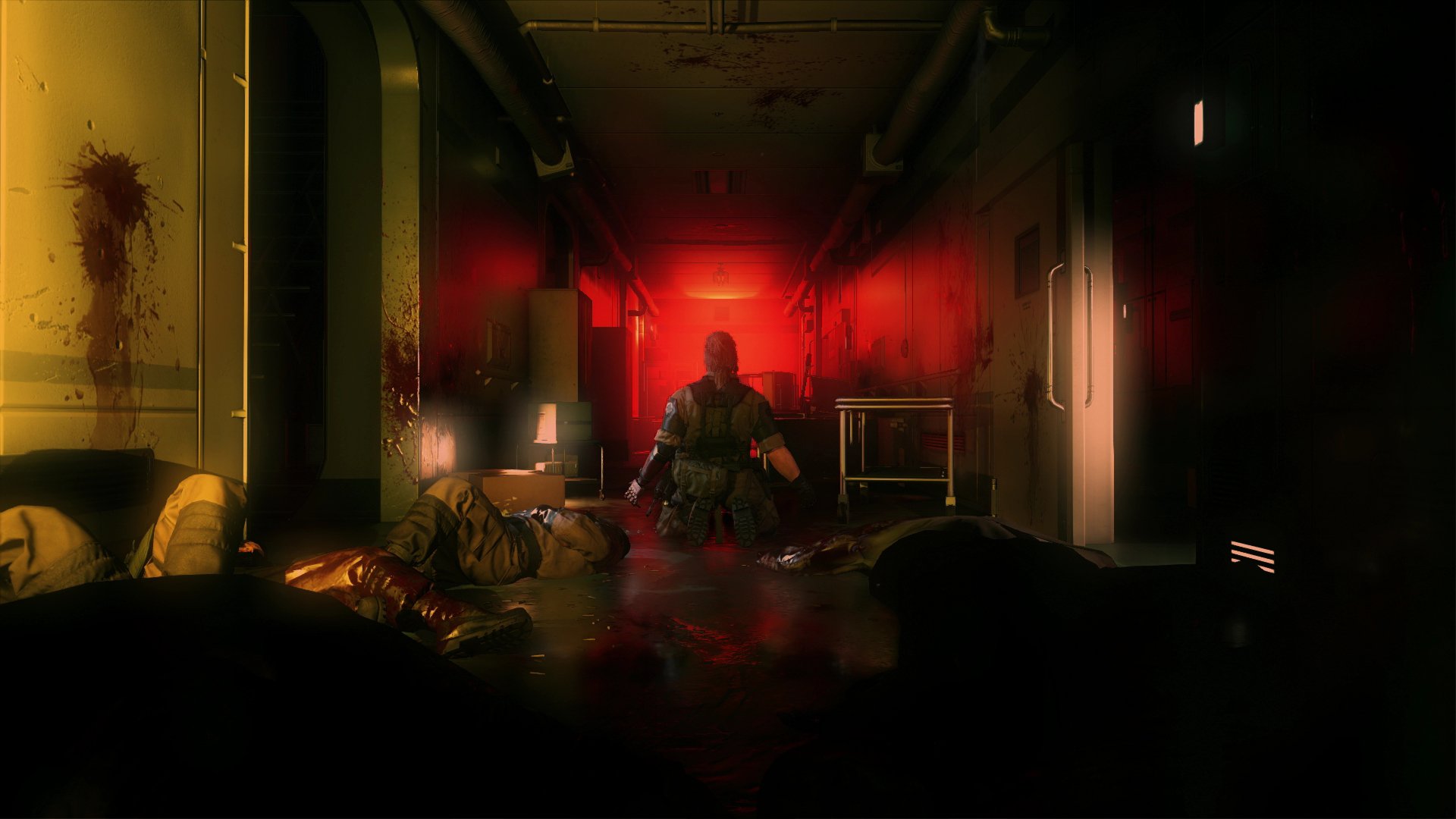 HD PC desktop wallpaper from the video game Metal Gear Solid V: The Phantom Pain, featuring a soldier kneeling in a dark, red-lit corridor with fallen figures around.