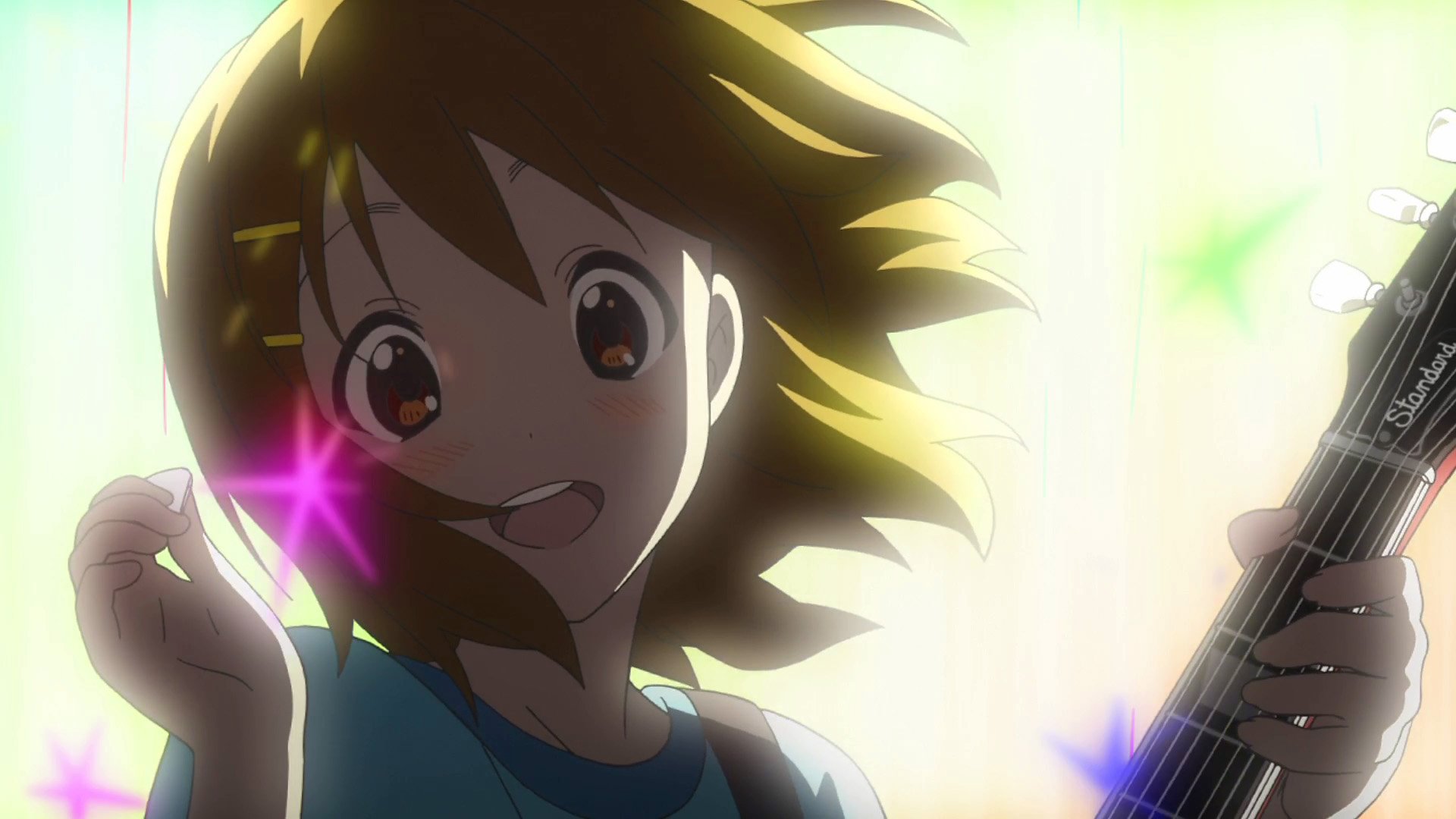 HD PC desktop wallpaper featuring Yui Hirasawa from the anime K-ON! with bright lighting and colorful star effects.