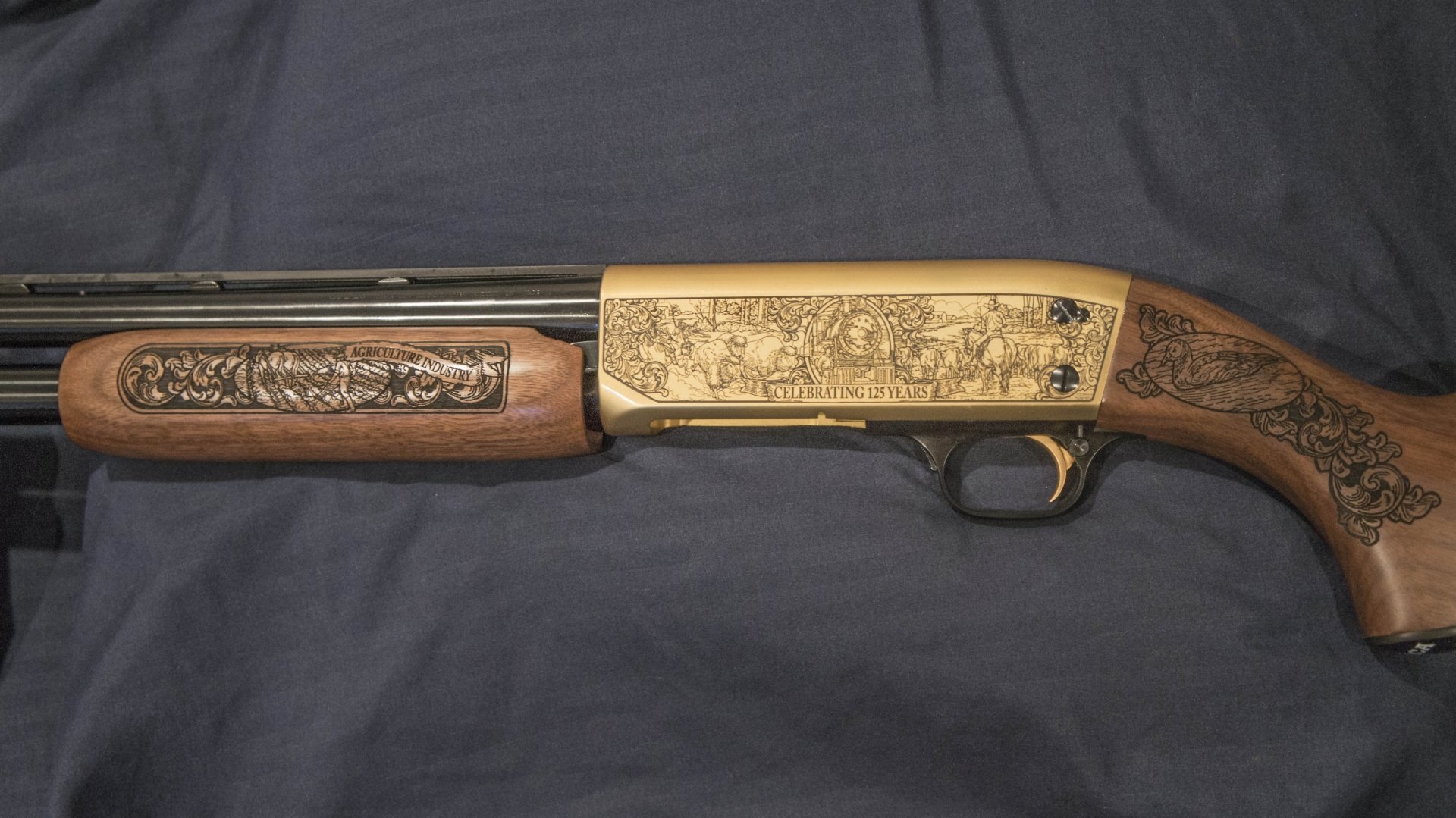4K Ultra HD desktop wallpaper showing a close-up of a man-made shotgun with detailed engravings on its wooden and metal parts against a dark fabric background.