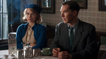 Keira Knightley and Benedict Cumberbatch sit at a table in a scene from the movie *The Imitation Game*, set in a vintage café with classic décor.