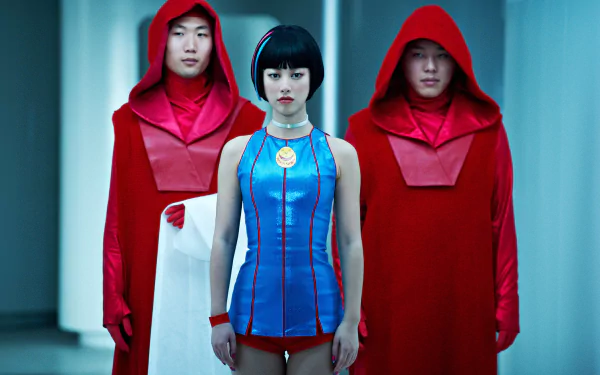 HD PC desktop wallpaper background from the movie Cloud Atlas: a woman in a blue futuristic outfit and medallion stands between two red-hooded figures holding a white cloth.