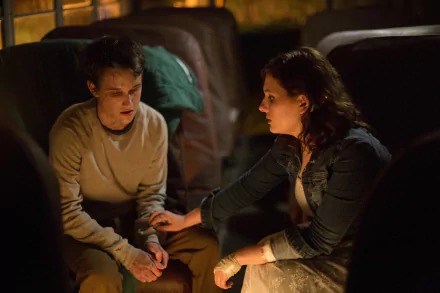 2K Quad HD PC desktop wallpaper from the movie Maggie (2015): two characters in a dim bus interior, one comforting the other by gently holding their hand.