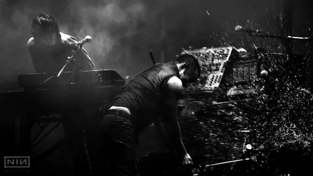 Black and white HD desktop wallpaper of Nine Inch Nails performing live, capturing intense energy and moody lighting in a music concert setting.