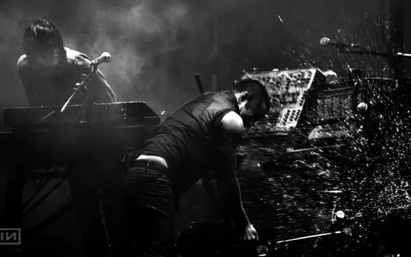 Black and white HD desktop wallpaper of Nine Inch Nails performing live, capturing intense energy and moody lighting in a music concert setting.