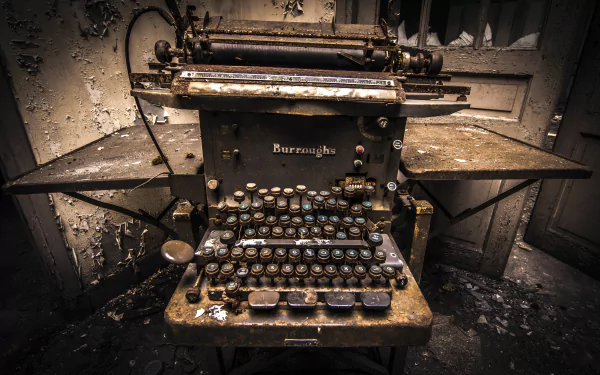 4K Ultra HD desktop wallpaper of an old, weathered Burroughs typewriter in a dim, abandoned setting showcasing man-made vintage technology.
