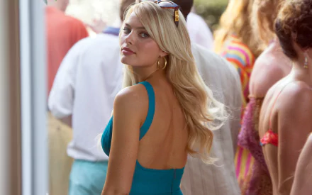 Naomi Lapaglia, portrayed by Margot Robbie in *The Wolf of Wall Street*, turns to look back amidst a lively crowd, captured in a vibrant HD wallpaper scene.