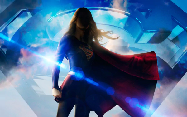 A dynamic HD wallpaper featuring Melissa Benoist as Kara Zor-El from the TV show Supergirl, showcasing her iconic pose with a glowing emblem and a vibrant background.