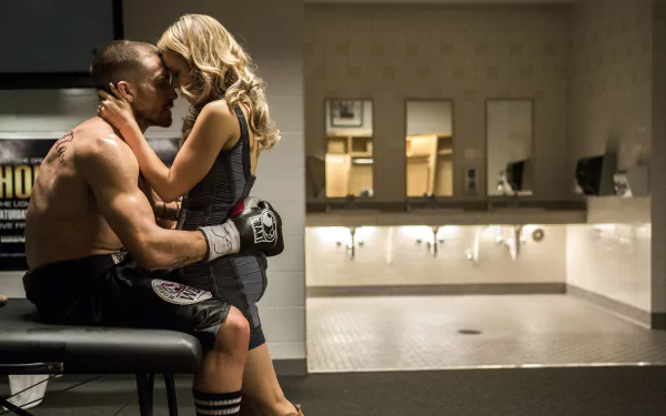 A romantic moment between Rachel McAdams and Jake Gyllenhaal in a scene from the movie Southpaw. The image captures their emotional connection amid a boxing backdrop.