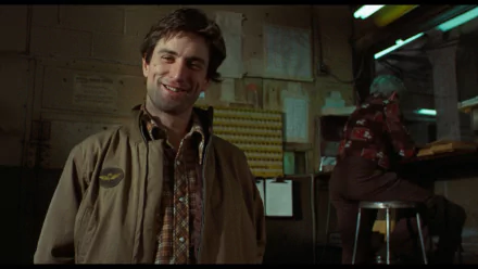 Robert De Niro smiles in a scene from Taxi Driver, captured in this HD desktop wallpaper, showcasing the film's iconic atmosphere and gritty character depiction.